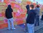 On the corner of Chalk Farm Road, near the tube and Camden High Street in London passing people are encouraged to write political messages on a wall.