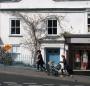 Stylish house and people walking past campaign poster for Sue Farrant, West Dorset Liberal Democrat. April 2010.